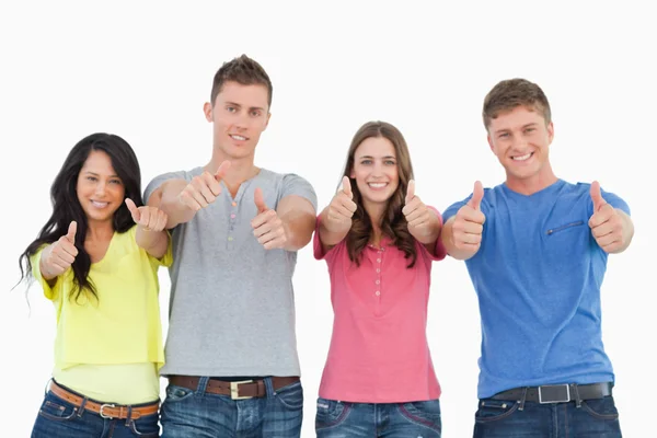 Four friends giving the camera the thumbs up — Stock Photo, Image