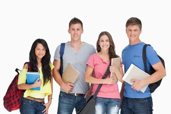 Students looking at the camera as they hold notepads Stock Photo