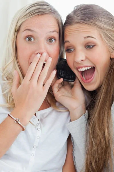 Sorprendido y feliz de las niñas haciendo una llamada como una chica mira la c — Foto de Stock