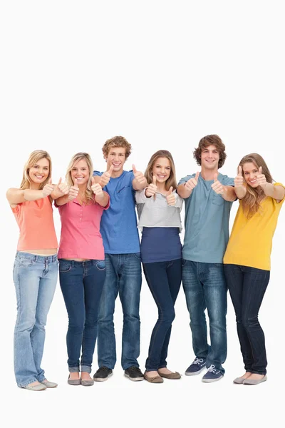 Un grupo sonriendo y levantando los pulgares — Foto de Stock