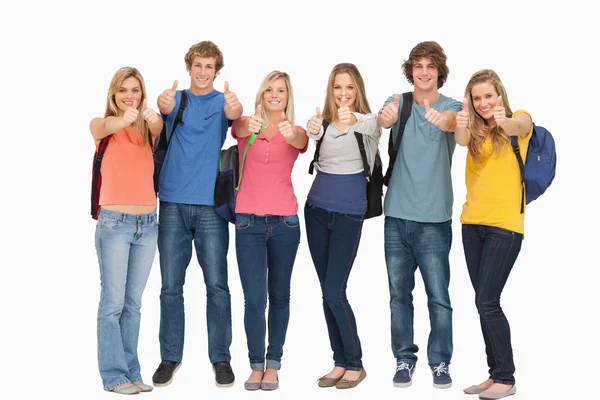 Sorrindo grupo dando um polegar para cima como eles usam mochilas — Fotografia de Stock