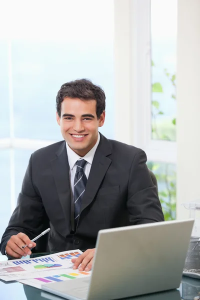 Homem trabalhando no gráfico enquanto sorri — Fotografia de Stock