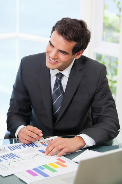 Mann zeigt auf eine Grafik, während er wegschaut — Stockfoto