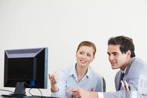 Kollegen zeigen etwas auf einen Computer — Stockfoto