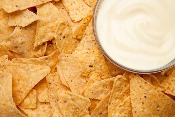 Nachos em torno de uma tigela de mergulho branco — Fotografia de Stock