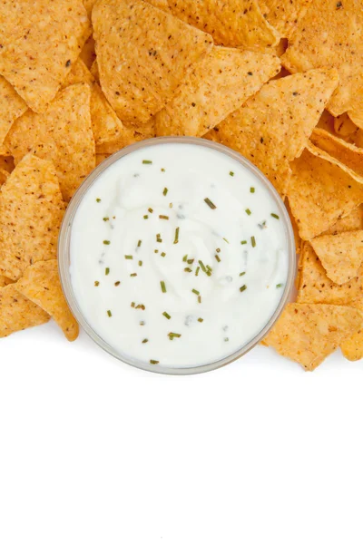 Close up of a bowl of dip with herbs surrounded by nachos — Stock Photo, Image