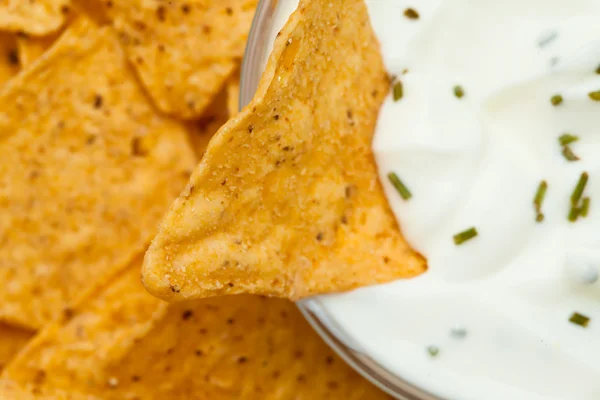 Close up of a nacho dipped into a bowl of dip — Stock Photo, Image