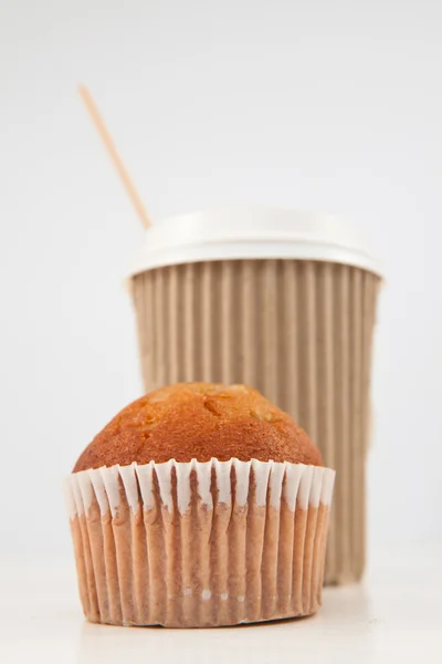 Muffin e xícara de chá colocados juntos — Fotografia de Stock