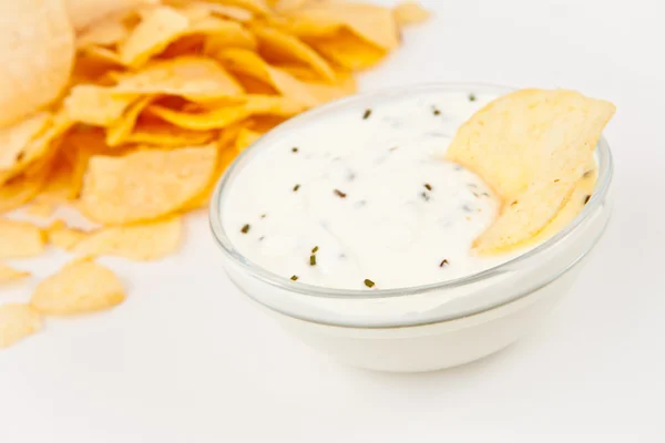 Bowl of dip with herbs beside chips — Stock Photo, Image