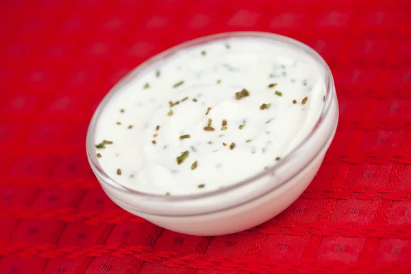 Bowl of white dip on a red tablecloth — Stock Photo, Image