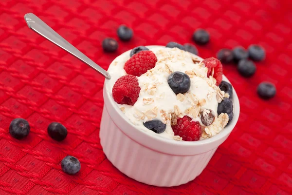 Pot of berries and whipped cream with spoon — Stock Photo, Image