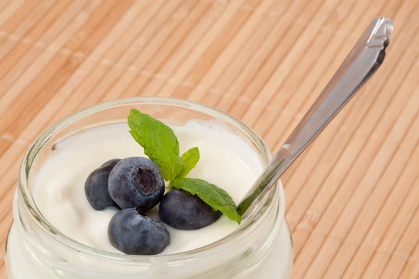 Primer plano de cuatro arándanos en un yogur — Foto de Stock