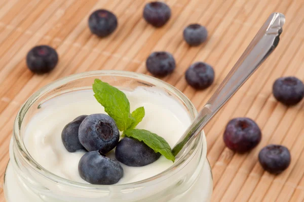 Nahaufnahme vieler Blaubeeren in einem Topf mit Joghurt — Stockfoto