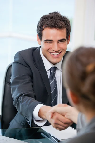 Geschäftsmann schüttelt lächelnd einem Kunden die Hand Stockbild