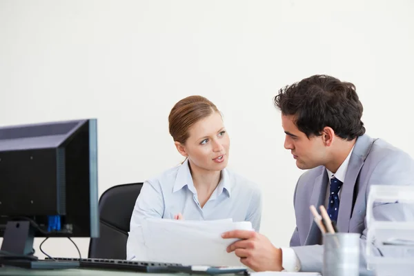 Colleagues talking while holding a sheet — Stock Photo, Image