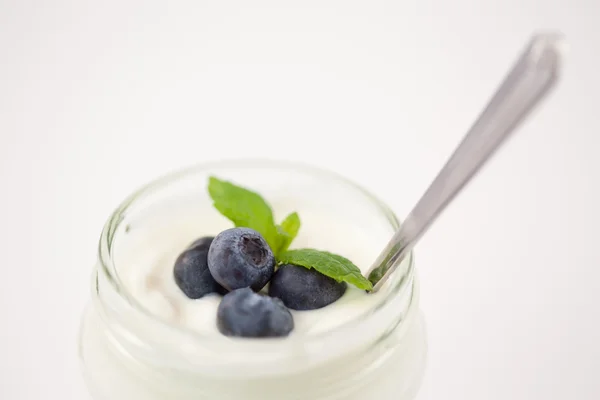 Close up of a pot of yoghurt with blueberries and fresh mint Royalty Free Stock Images