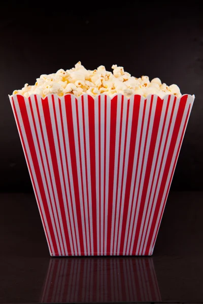 Box of pop corn on a black table — Stock Photo, Image