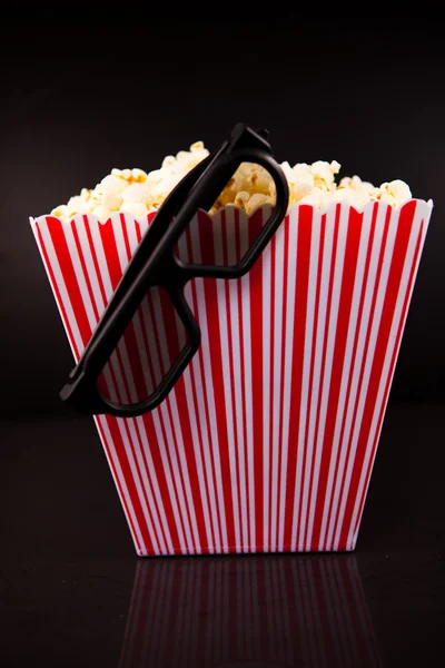 3D-s szemüveg lóg a szélén egy doboz tele pop corn — Stock Fotó