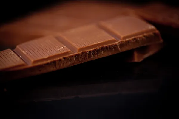 Barre de chocolat couchée sur du chocolat — Photo