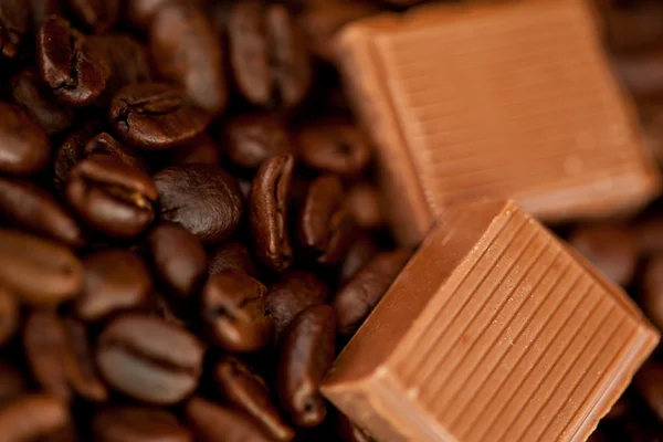 Chocoladestukjes en koffiebonen naast elkaar — Stockfoto