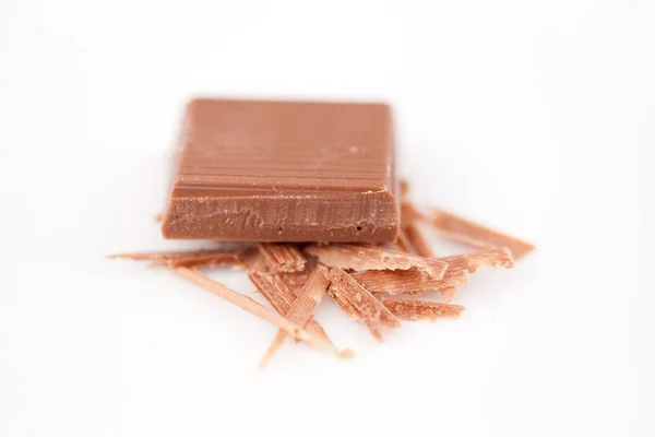 Piece of chocolate on chocolate shavings — Stock Photo, Image