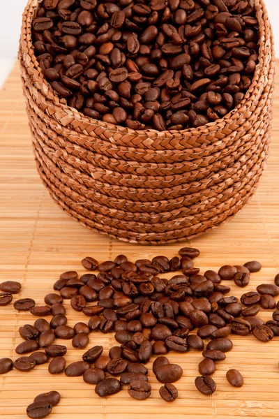 Close up of a basket filled with coffee seeds on a wooden tablec — Stock Photo, Image