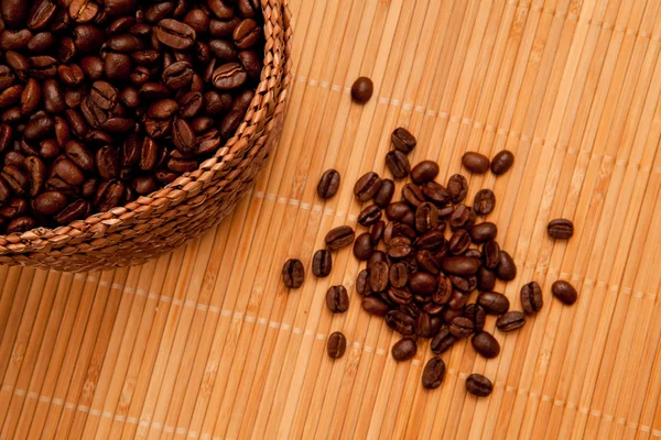 Seeds in front of a basket full of coffee seeds — Stock Photo, Image