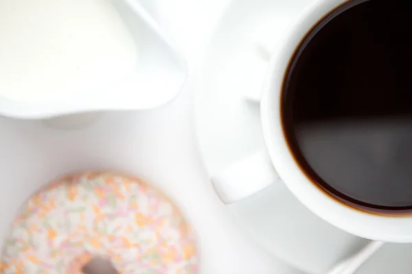 Tasse de café avec un beignet — Photo