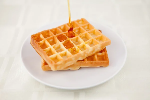 Honey falling on a waffle — Stock Photo, Image