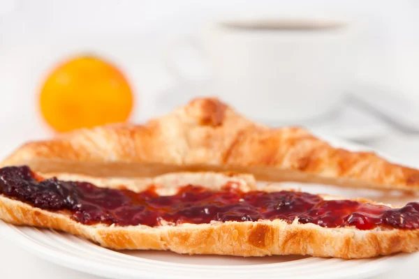 Tazza di caffè posta dietro un croissant — Foto Stock