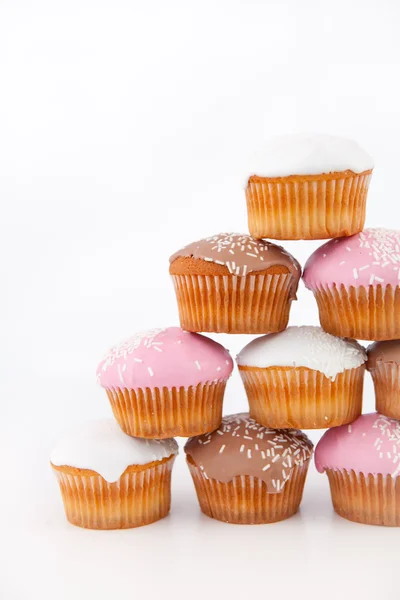 Muitos muffins com açúcar gelado colocados em pirâmide — Fotografia de Stock