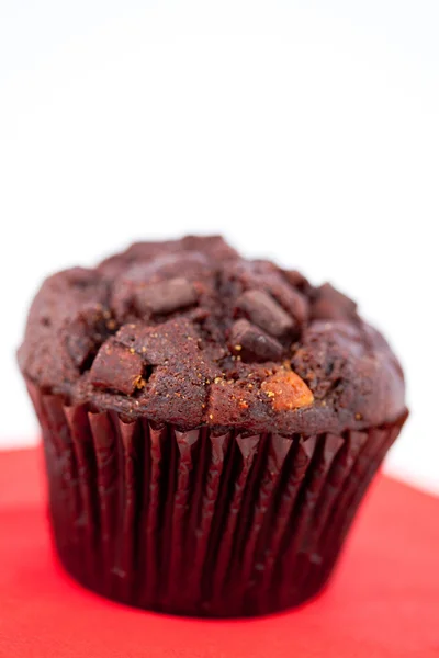Dark chocolate muffin on a red table — Stock Photo, Image