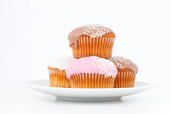 Muffins met suikerglazuur suiker stapels omhoog op een witte plaat — Stockfoto