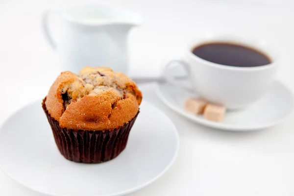 Muffin e una tazza di caffè su piatti bianchi con zucchero e latte — Foto Stock