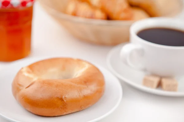 Donut e uma xícara de café em pratos brancos com açúcar e leite — Fotografia de Stock