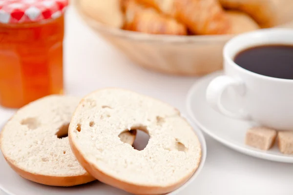 Donut corte ao meio e uma xícara de café em pratos brancos com su — Fotografia de Stock