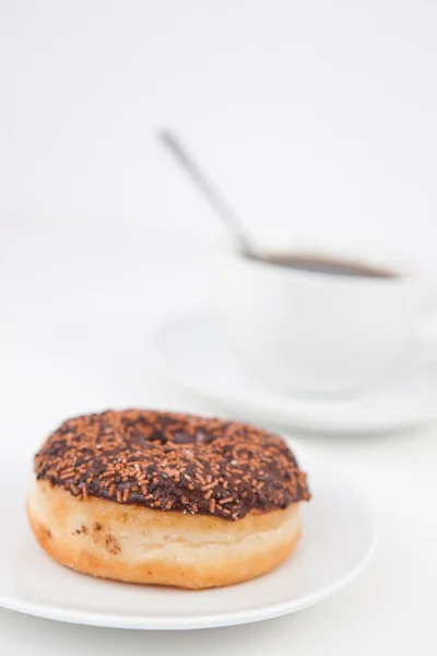 Chocolate doughnut and a cup of coffee on white plates — Stock Photo, Image