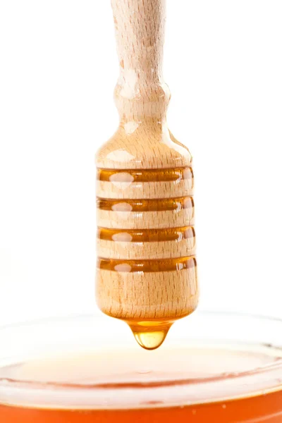 Honey drop on the top of a honey bowl — Stock Photo, Image