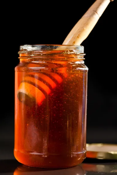 Honey full jar with a honey dipper — Stock Photo, Image