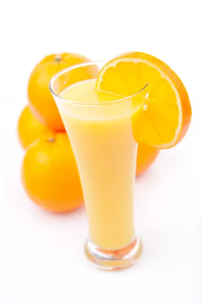 Volles Glas Orangensaft in der Nähe eines Orangenhaufens — Stockfoto