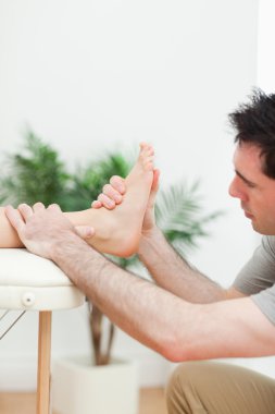 Close up of a physiotherapist massaging a foot clipart