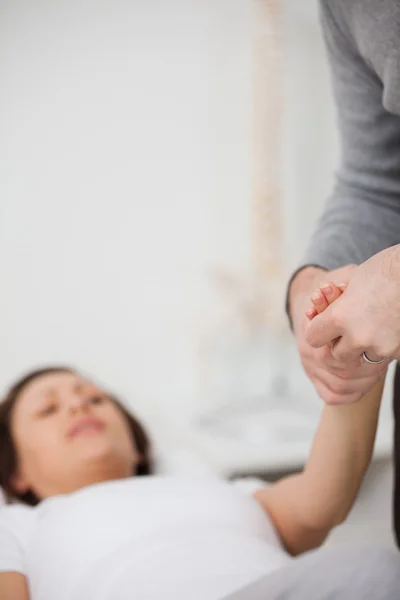 Fisioterapeuta sosteniendo una mano dolorosa — Foto de Stock