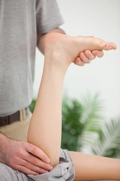 Woman lying forward while being stretched — Stock Photo, Image