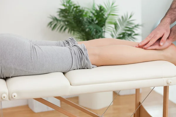 Fisioterapeuta massagear as pernas de uma mulher — Fotografia de Stock