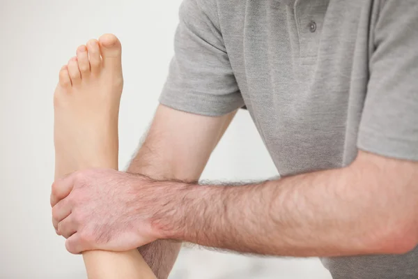 Close-up of a physiotherapist manipulating an ankle — Stock Photo, Image