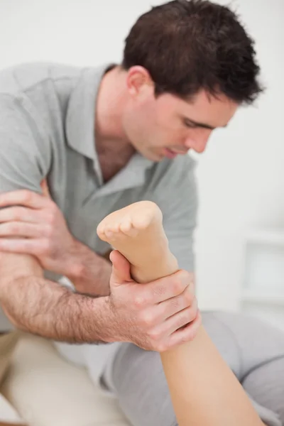 Chiropractor massaging a patient with his elbow — Stock Photo, Image