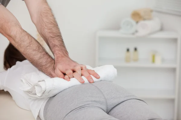 Masajista masajeando a una mujer con una toalla — Foto de Stock