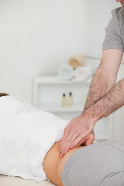 Vrouw liggen terwijl een fysiotherapeut is het masseren van haar rug — Stockfoto