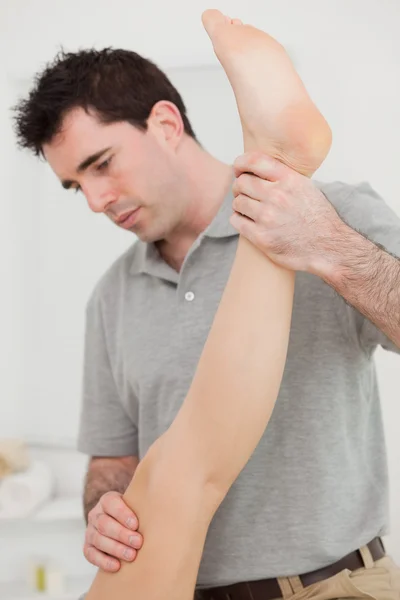 Chiropractor extending the leg of a patient — Stock Photo, Image