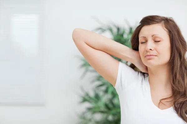 Vrouw die haar hand op haar pijnlijke nek brengen — Stockfoto